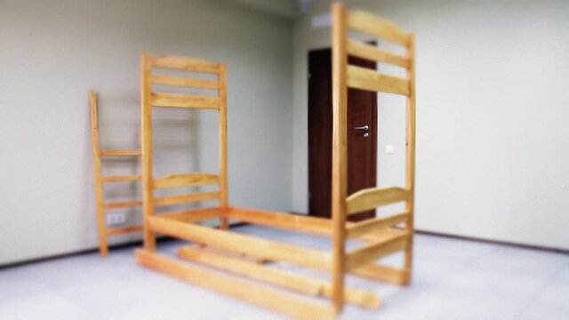 sequential assembly of a Bunk wooden bed with ladder and mattresses, Tilt-Shift video.