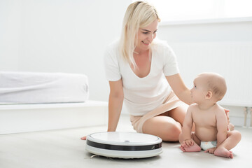 Robotic vacuum cleaner next to the baby girl
