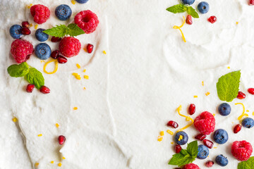Whipped cream from egg whites with raspberries, blueberries, pomegranate. Composition of berries...