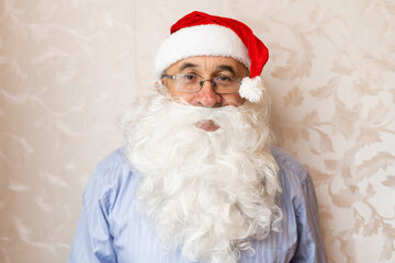 portrait of senior man in santa hat looking at camera