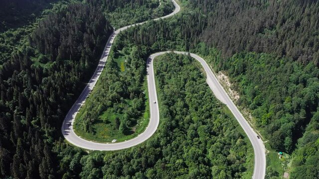 Flight over the summer mountains with mountain road serpentine