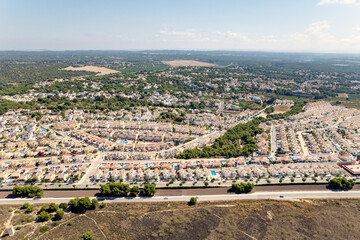 Pinar de Campoverde residential district view from above. Drone point of view luxury summer villas with swimming pools townscape rooftops at sunny summer day. Costa Blanca, Province of Alicante, Spain