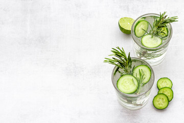 Cold soda drink with pieces of cucumber lime and herbs