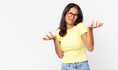 pretty thin hispanic woman shrugging with a dumb and puzzled expression