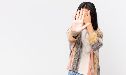 pretty thin hispanic woman covering face with hand