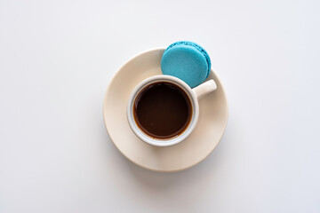 Coffee cup and French macarons on white background. Top view.