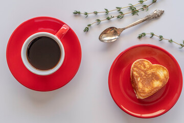 Cup of coffee, heart shaped pancake on white background. Coffee break concept.