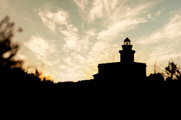 Fototapeta na wymiar Silhouette view of lighthouse in Capo Testa at sunset - Sardinia