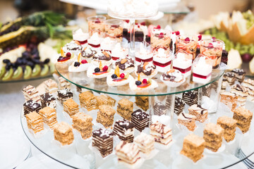 Delicious and tasty dessert table with cupcakes shots at reception closeup