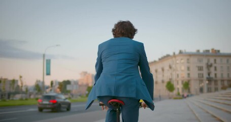 Follow shot of businessman commuter with electric bicycle traveling to work in city.