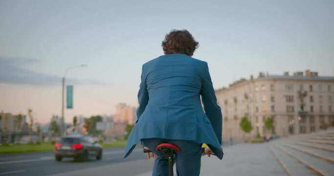 Follow shot of businessman commuter with electric bicycle traveling to work in city.