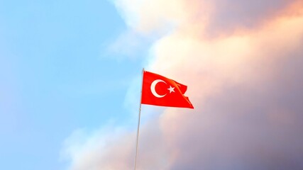 Turkey flag close-up on a background of forest fire smoke clouds. Selective focus.