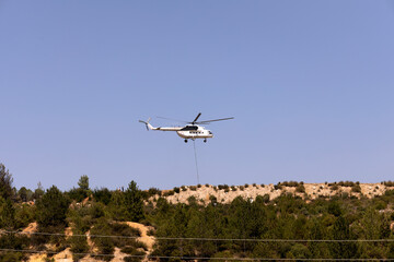 fire fighting helicopter leaves water to the forest fire
