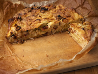 Quiche with potatoes and leeks on baking paper, vegetarian food, healthy eating