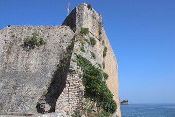 The old fortress wall and the sea. Sunny day and bright blue sky. Travelling and adventures....
