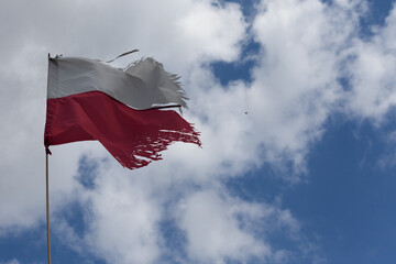Old Polish flag against the blue sky.