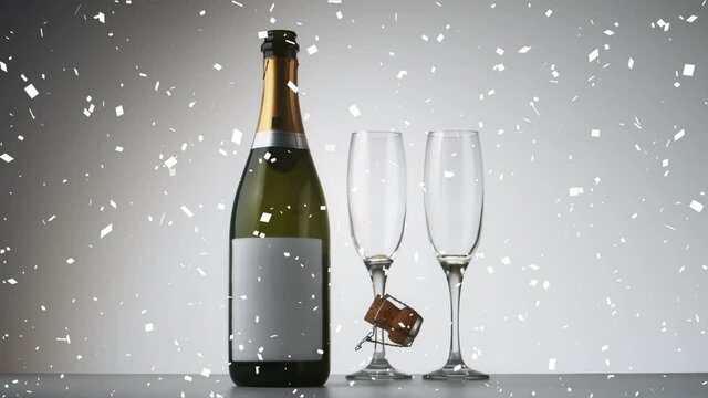 Animation of confetti falling over bottle and glasses of champagne