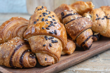 Chocolate croissant on wooden background.
