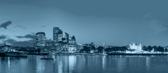Panorama of the Tower Bridge, Tower of London and modern skyline on Thames river at dusk - London,...