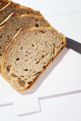 Pieces of bread on a cutting board top view on white clean plastic cutting board