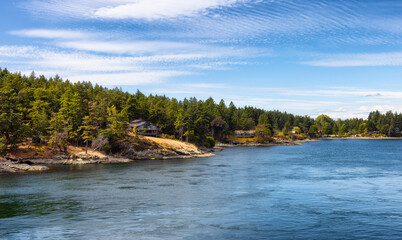 Panoramic View of a Cosy Homes on the rocky coast during a sunny summer day. Taken on Galiano Island near Vancouver Island, BC, Canada.