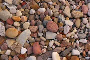 Background from colored stones on the coast. Stones of different sizes and shapes.