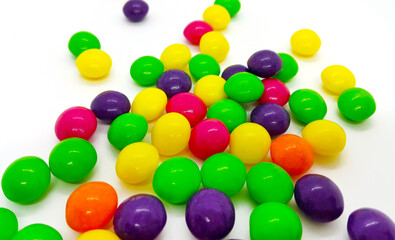 Fototapeta na wymiar Bright jelly bean in a multicolored glaze on white background