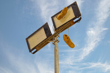 Um par de tênis pendurado num poste de iluminação pública.