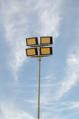 Um poste de iluminação pública com céu azul.