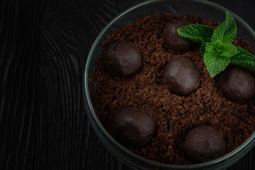 Chocolate dessert of cookies with pieces of chocolate and mint on a dark wooden background with copyspace, food and drink concept