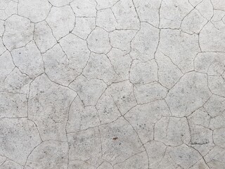 Cracks on the white concrete pavement.