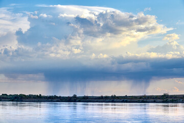Fototapeta na wymiar panoramic view of raining clouds over wide steppe river with a calm current
