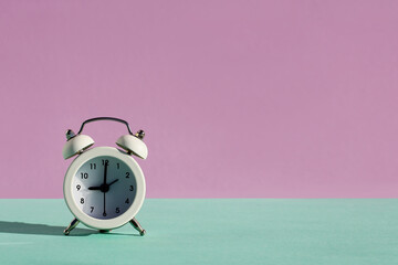 vintage classic white alarm clock, minimal design bell on violet-blue pastel background. Rest hours time of life, good morning, wake up awake concept