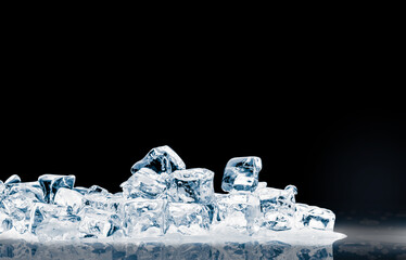 The heap of shiny natural ice cubes on a black background.