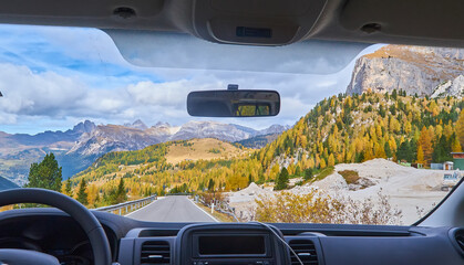 view on the Alps through the windscreen of the car while driving on the curvy road. - 450393239