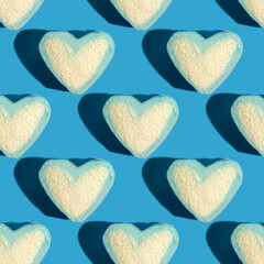 Seamless pattern with heart shaped marshmallow on blue background.