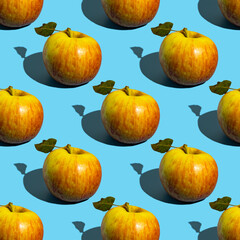Seamless pattern with whole apples on blue background.