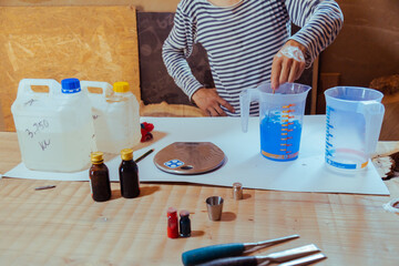 Closeup carpenter preparing epoxy resin for woodworking and carpentry production