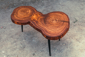 Live edge elm slab coffee table with epoxy finish. Woodworking and carpentry production. Close-up....