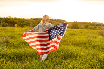 country, patriotism, independence day and people concept - happy smiling young woman with national american flag on field