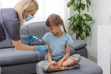 nurse giving vaccination injection to little girl patient