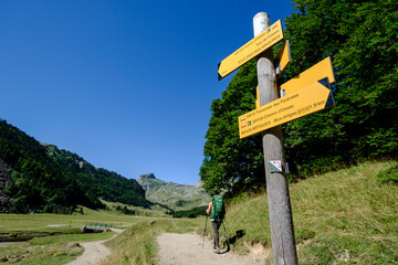hikers and indicative sign, Ayous lakes tour, Pyrenees National Park, Pyrenees Atlantiques, France