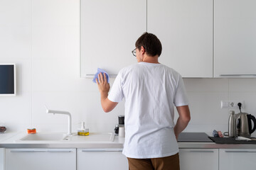 Man cleaning the kitchen surfaces