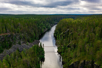 Aerial view of a suspension bridge crossing a lake in forest. Julma-Ölkky in Hossa National Park,...