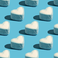 Seamless pattern with heart shaped marshmallow on blue background.