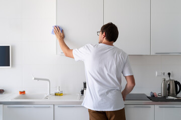 Man cleaning the kitchen surfaces