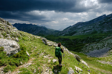 Fototapeta na wymiar hiker under a stormy sky, col de Anéou, Ayous lakes tour, Pyrenees National Park, Pyrenees Atlantiques, France