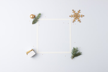 Christmas decorations with white frame and gift on white background. Flat lay, copy space