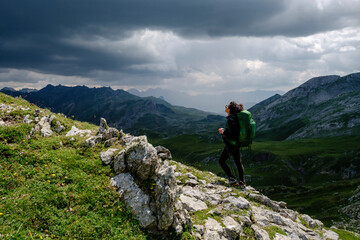 Fototapeta na wymiar hiker under a stormy sky, col de Anéou, Ayous lakes tour, Pyrenees National Park, Pyrenees Atlantiques, France
