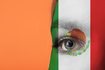 Young woman with face in colors of Mexican flag on orange background, closeup